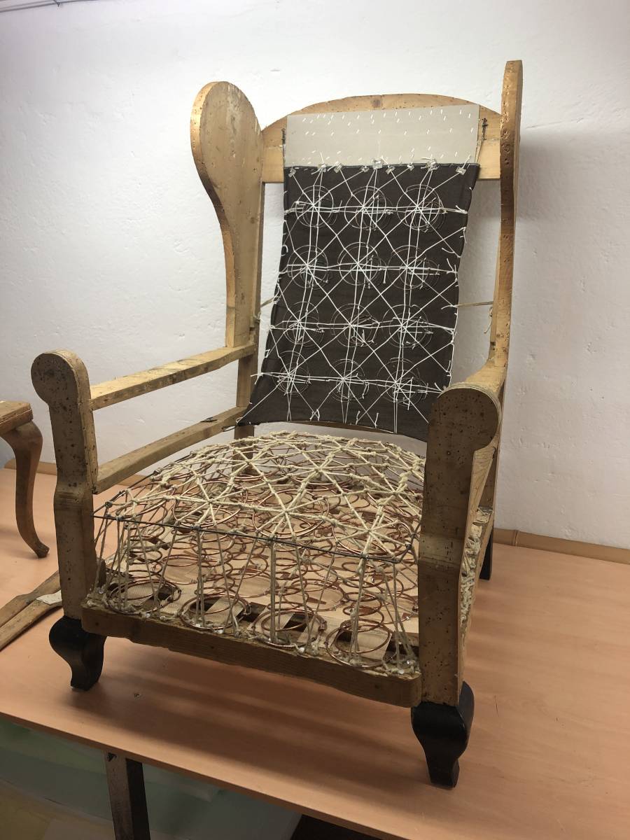 Odkryté pružinové jádro a popruhy křesla během renovace – tradiční čalounická technologie